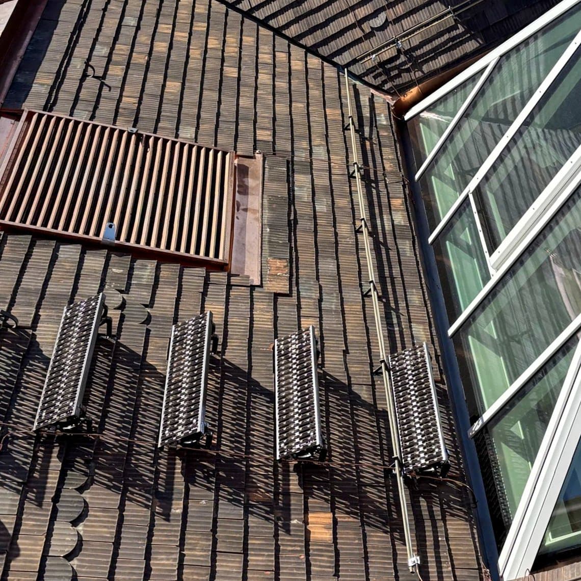 Dachdetail mit Ziegeldeckung, Schneefängern und Glasdach