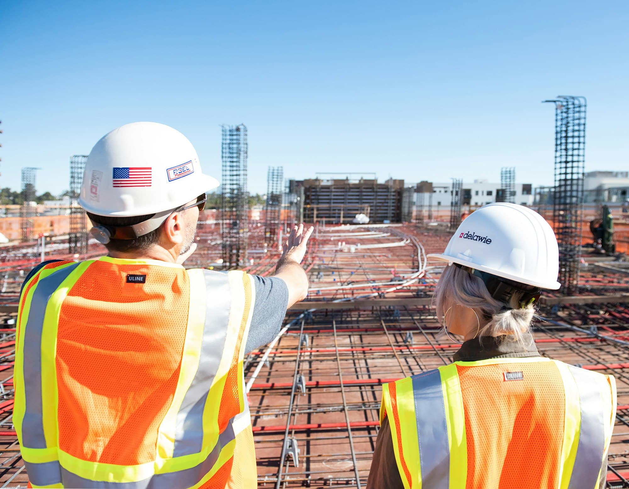 Bauleitung mit Schutzhelmen auf der Baustelle